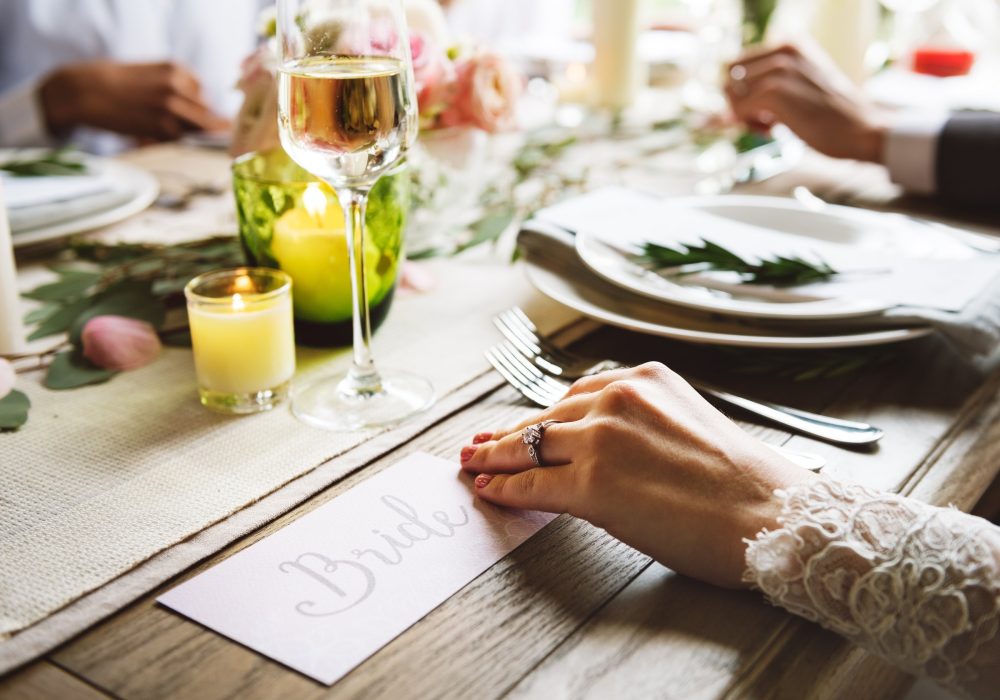 Hands writing a place card at a set table