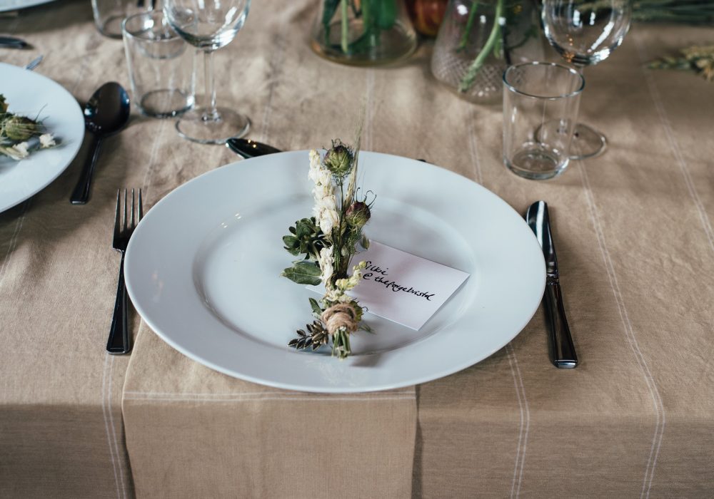 A single place setting with a sprig of greenery on the plate