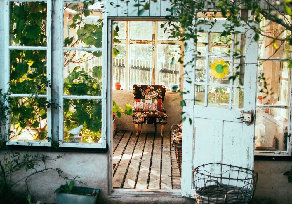 Weathered blue-green double doors open onto a planted garden room